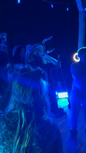 Infinite Cypher performers sharing the stage under blue lights at night