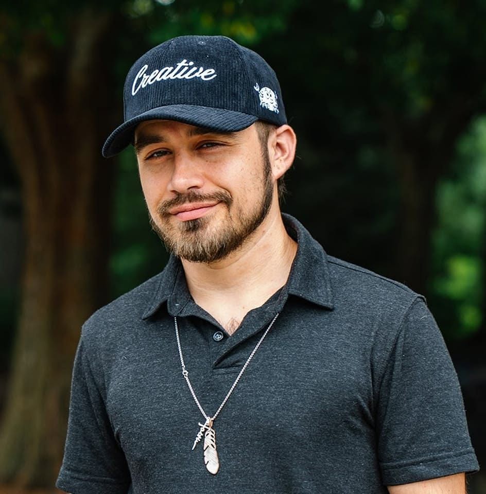Jon G outdoors, wearing a Creative cap and a dark polo