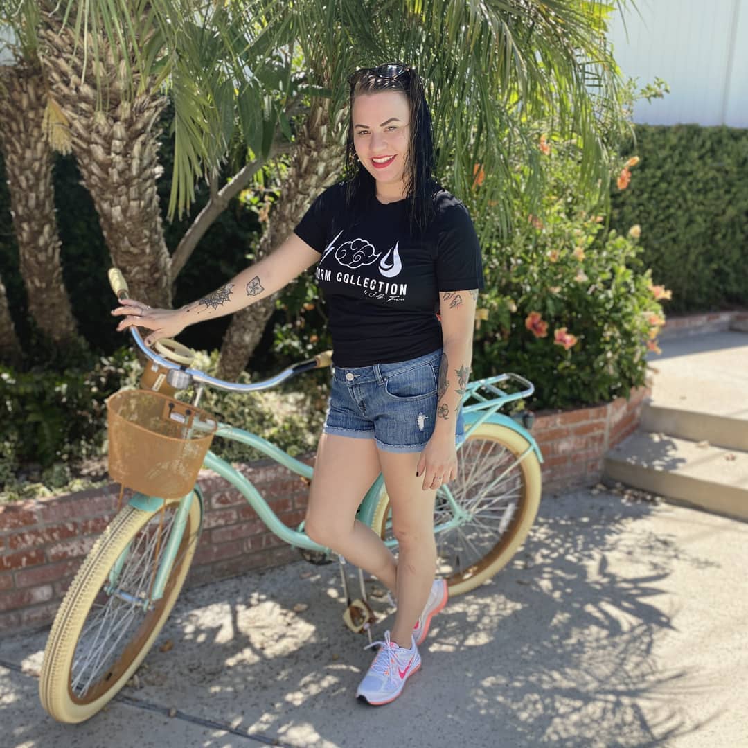 A Storm Collection community member wearing a branded shirt beside a bicycle
